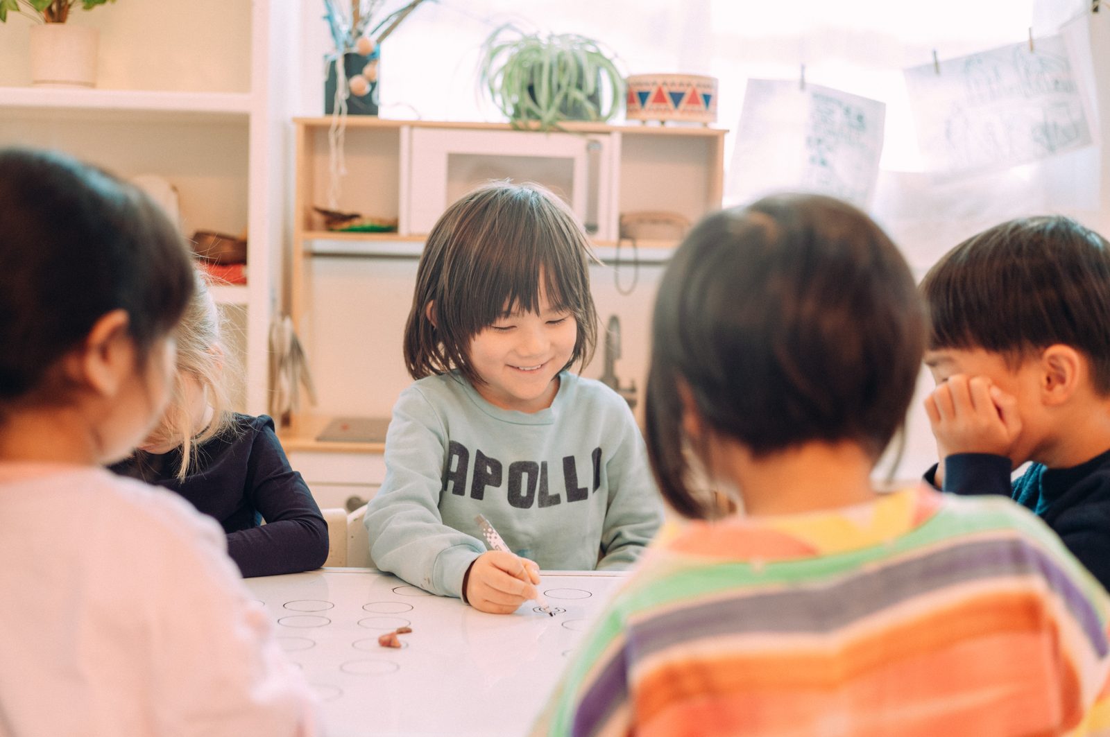 輪になって座り、笑顔で発表する男の子