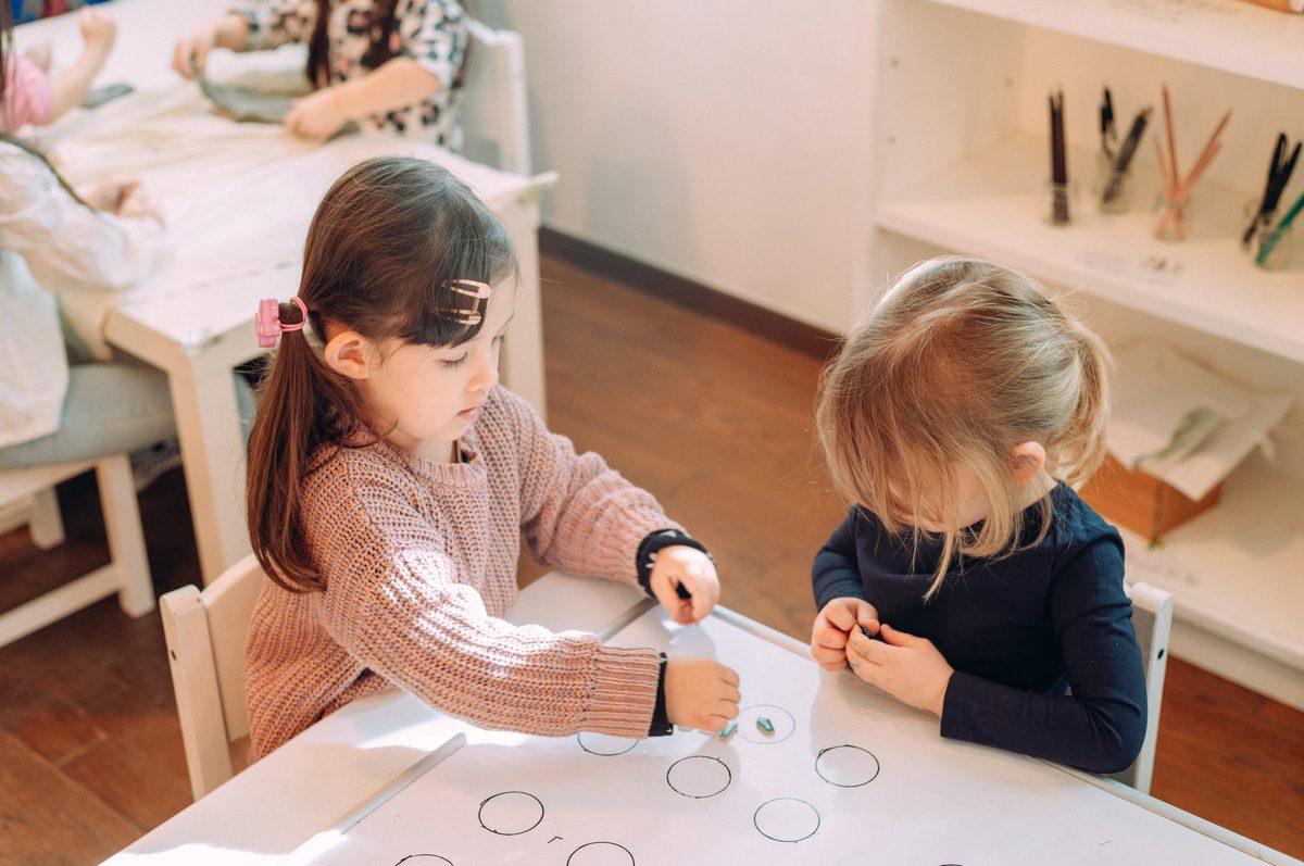 ホワイトボードに丸を描きながら学ぶ2人の女の子