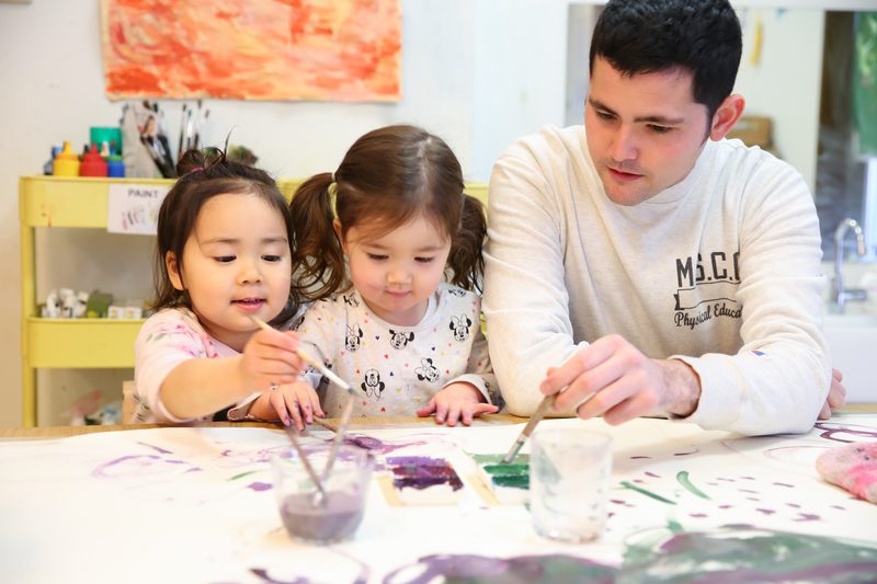 A toddler and teacher enjoying paint play together
