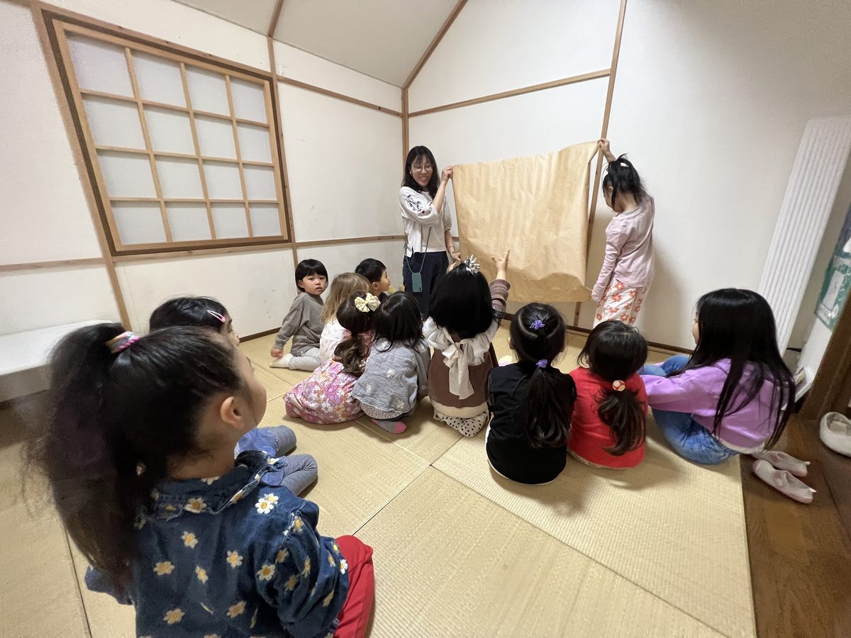 輪になって座り、先生の話に耳を傾ける子どもたち