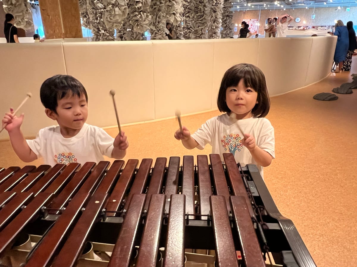 大きな木琴をマレットで叩いて音を楽しむ子どもたち